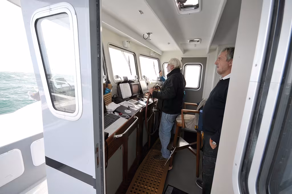 Captain Bob à la barre de son cata, bien protégé dans sa timonerie intérieure. Objectif : le grand départ !