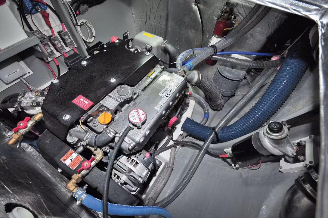 Une installation moteur pertinente et soignée, avec une implantation avancée dans le bateau pour un meilleur centrage des poids et la protection des blocs contre les aspersions (inévitables avec des capots de ponts !). Vue avec le panneau de visite ouv