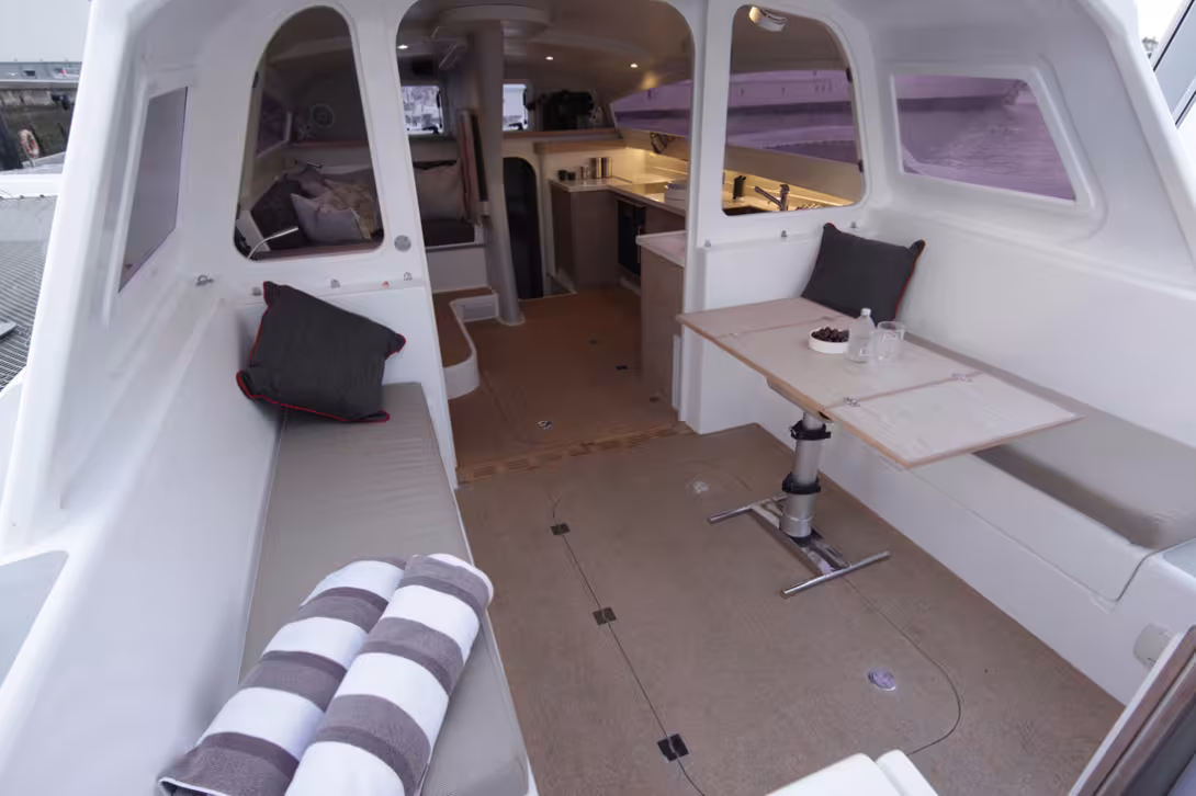 Le carré, le cockpit et la cuisine peuvent fusionner en un bel espace semi outdoor parfaitement protégé du vent, des embruns et du soleil (notez le carénage latéral qui ferme la zone pour les hautes vitesses). Ici, la porte de liaison est basculée e